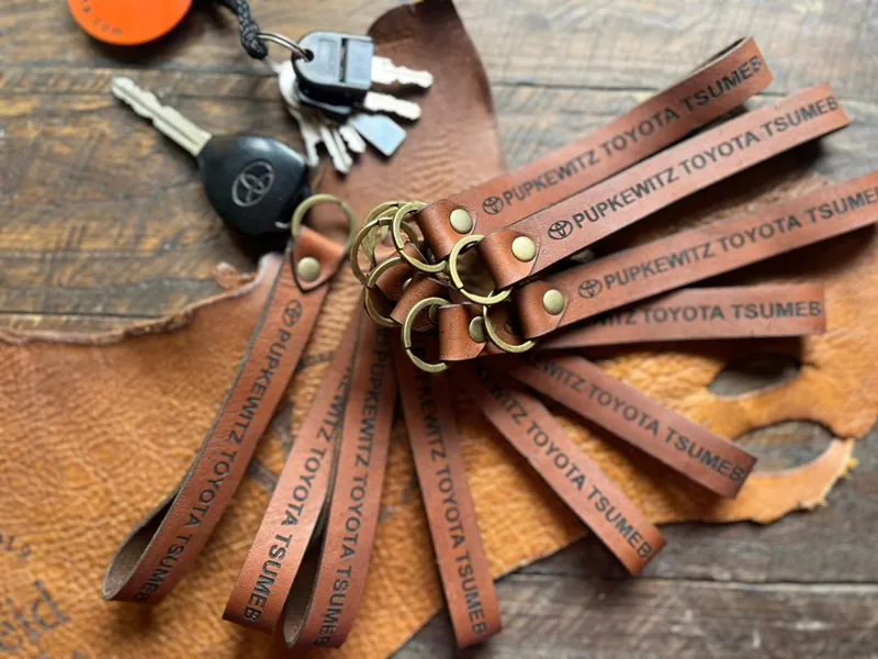 A batch of leather keychains engraved with a company name