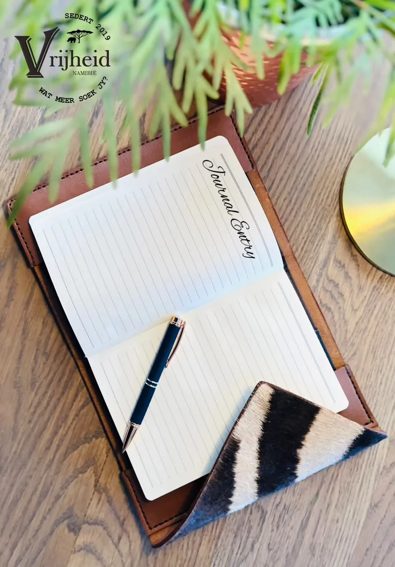 Leather notebook cover with a zebra-hide corner and a pen